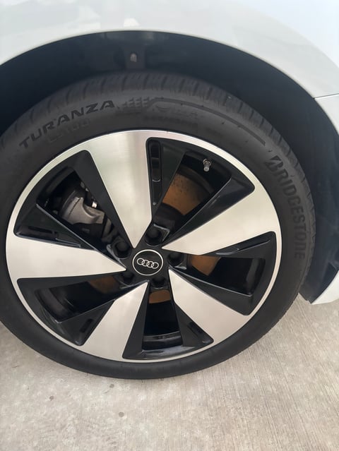 Audi vehicle wheel with black and white alloy rim and Bridgestone Turanza tire